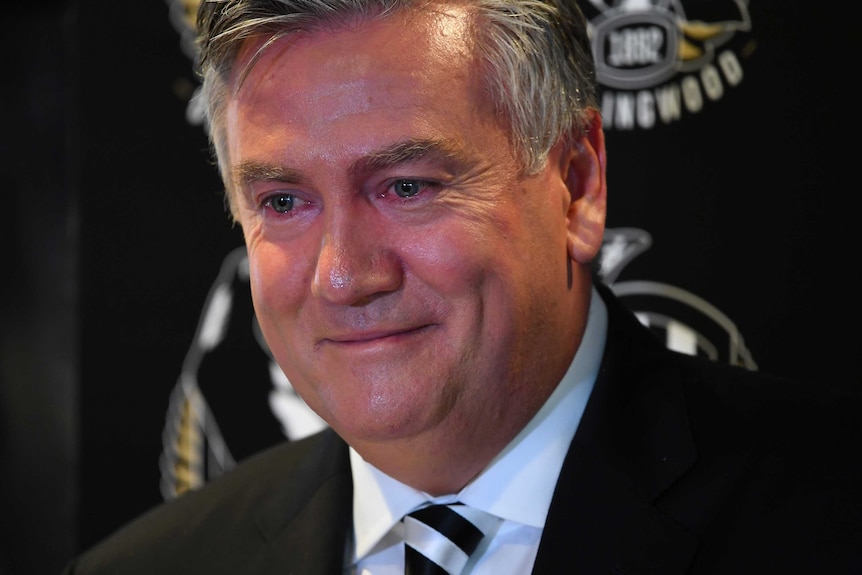 Eddie McGuire has red, teary eyes as he smirks during a press conference