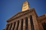 A majestic building with pillars and a clock at the top