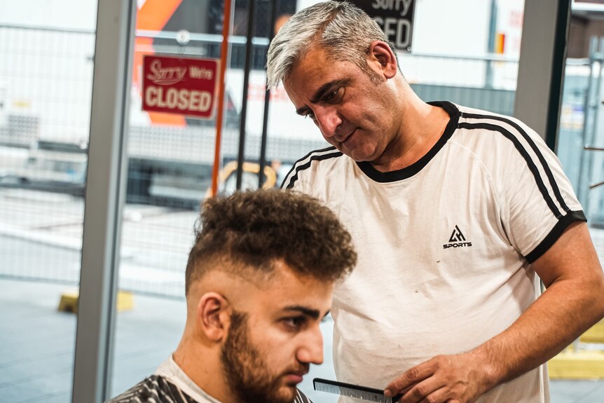 a barber cutting a young man's hair