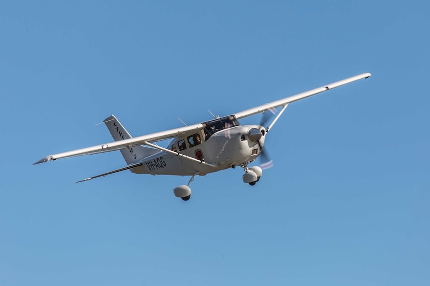 A light plane in flight with blue sky all around, 2016.