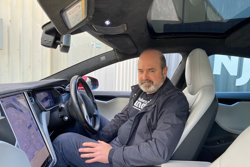 Man sits in his electric vehicle