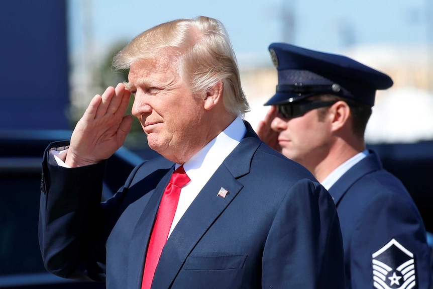 Donald Trump salutes as he disembarks Air Force One