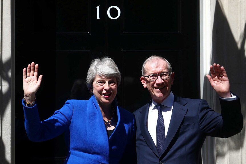 Theresa May and her husband Philip wave outside the black door of 10 Downing Street, London