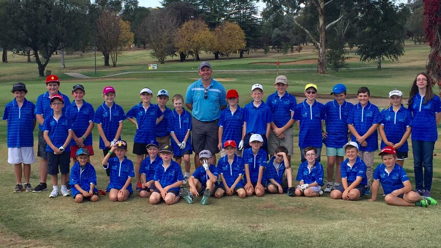 Bathurst's resident golf pro, Matt Barratt, centre, with a team of junior golfers around him.