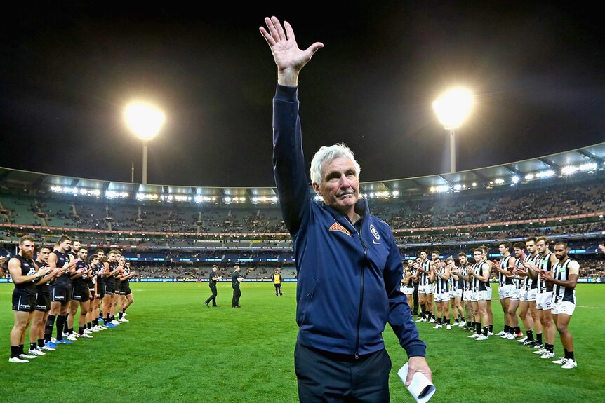 Michael Malthouse acknowledges the crowd at the MCG after breaking the record for the most AFL games coached