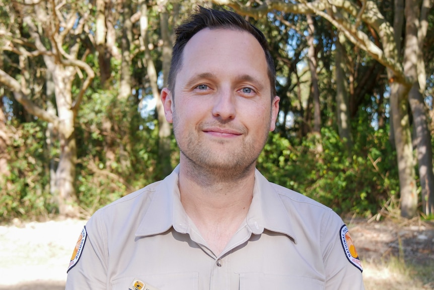 A profile shot of a man in a National Parks and Wildlife Service shirt. 