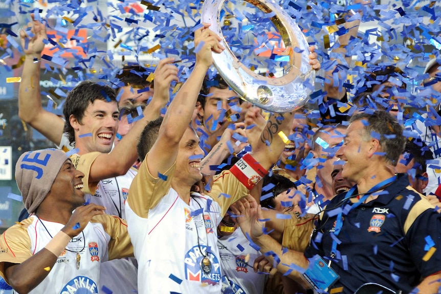 Jade North hold the trophy as the Newcastle Jets celebrate their 2008 victory.