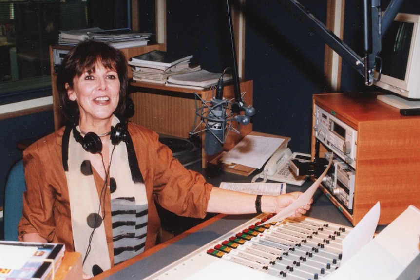 Margaret Throsby in radio studio with script in hand.