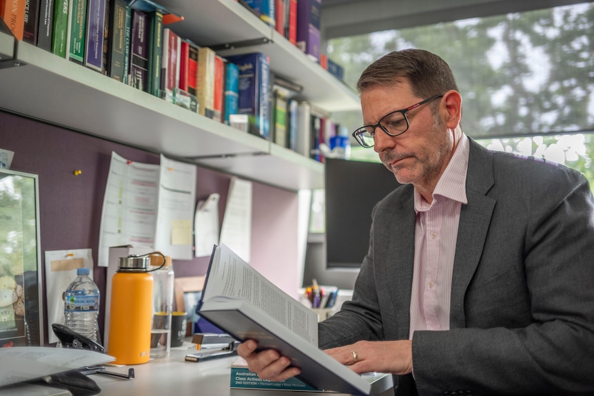 A man in an office reading a book