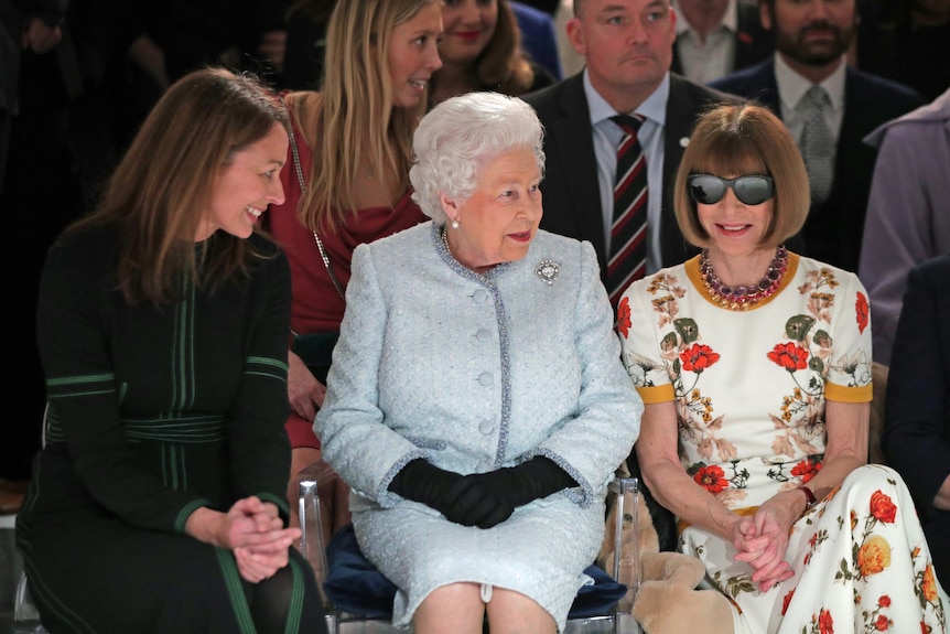 Queen Elizabeth wears a duck-egg blue suit in the front row of a fashion show