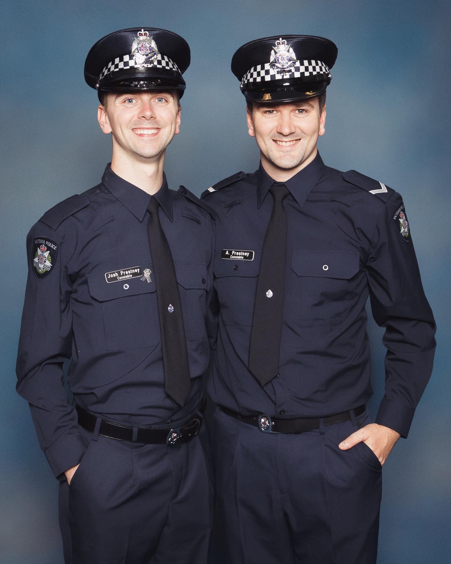 Two happy young men in police uniforms.