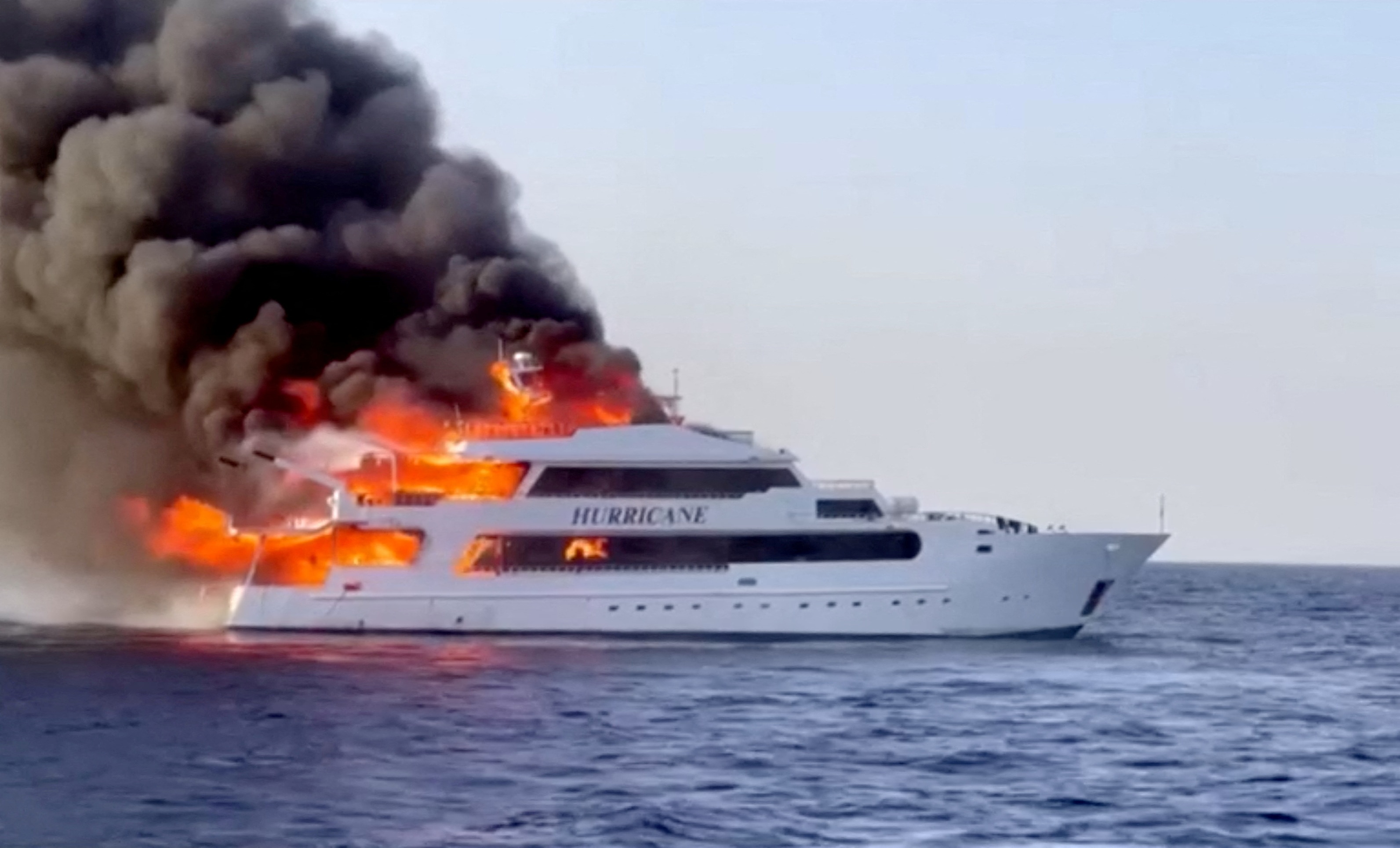 a medium sized yacht engulfed by flames 