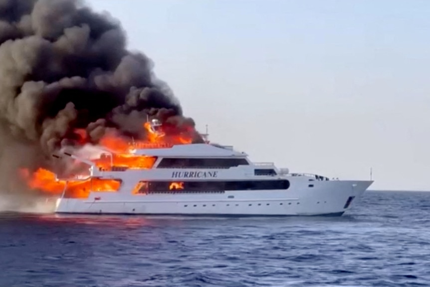 a medium sized yacht engulfed by flames 