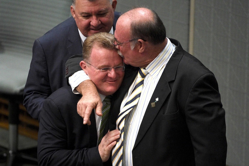 Bruce Billson is hugged by Warren Entsch in the House of Representatives on October 12, 2015