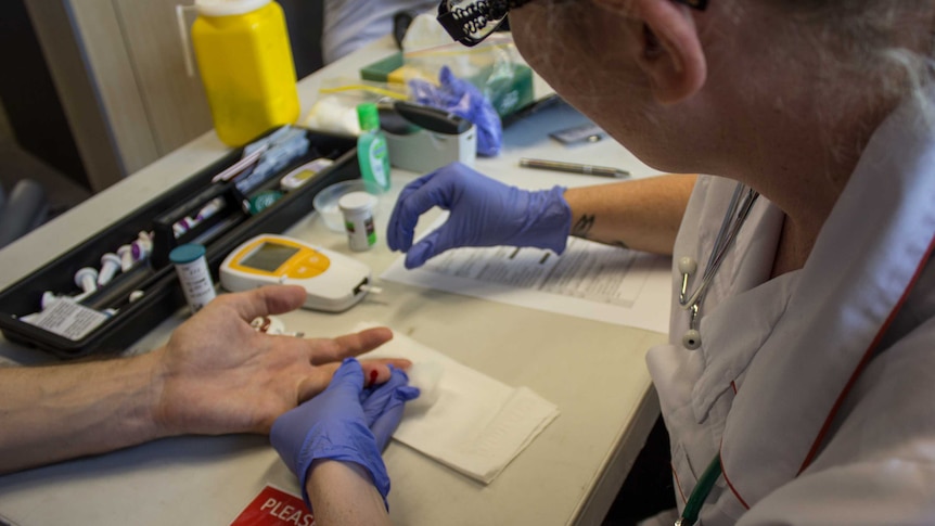 Generic shot of a nurse testing unidentified patient's blood sugar.