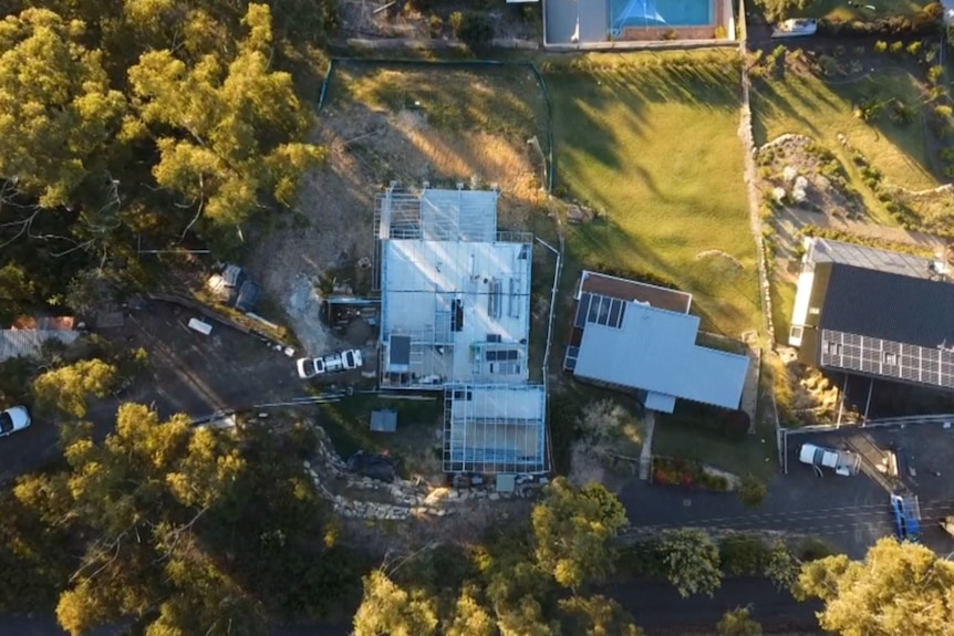 An aerial view of a property with a house being built and various outbuildings.
