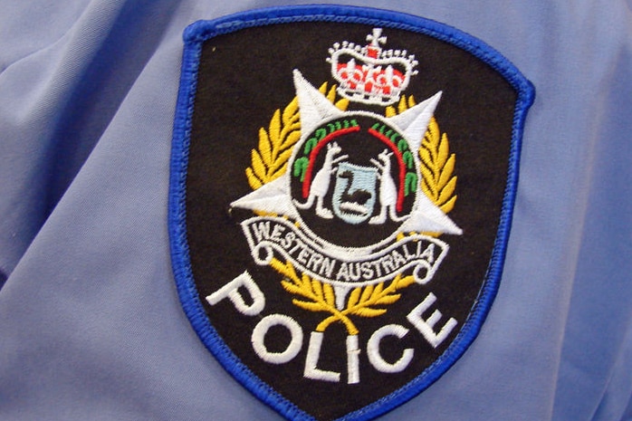 A close-up shot of a WA Police badge on a blue police shirt.