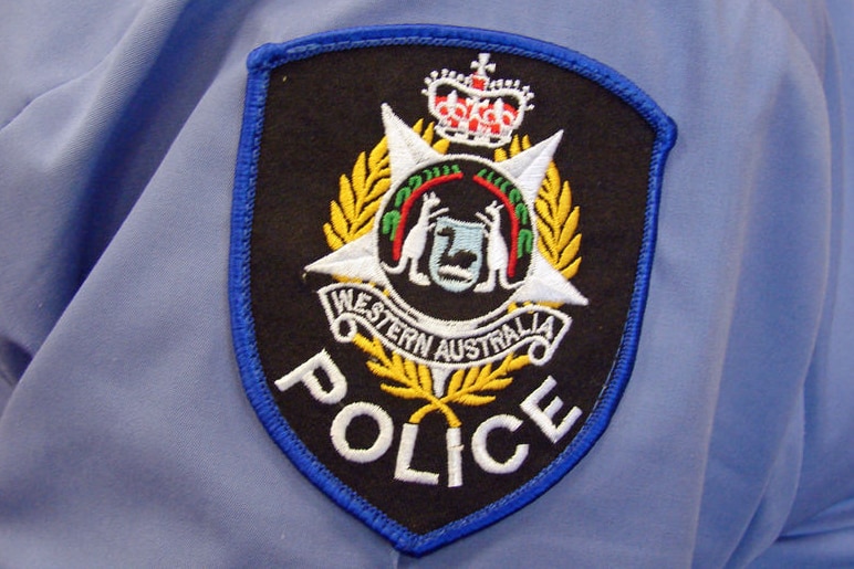 A close-up shot of a WA Police badge stitched onto an officer's blue shirt.