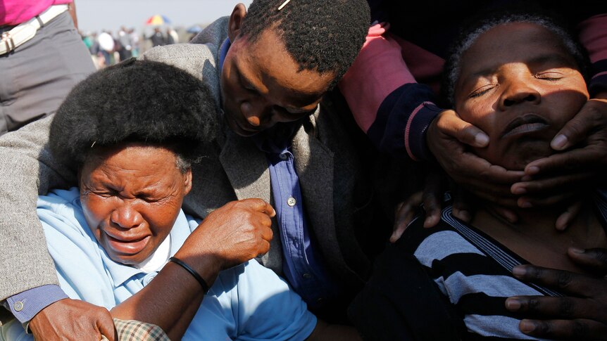 Relatives and family members of killed miners mourn at a memorial service in Rustenburg.