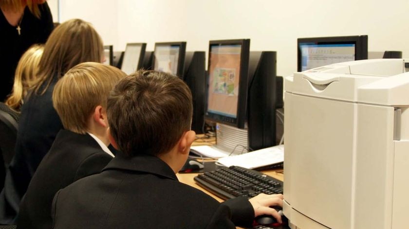 Children work on computers in a classroom
