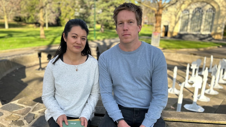 Emily and Nick Judd sit together in a park, and Emily holds a green book