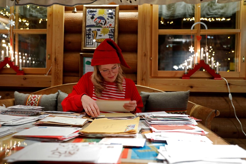 Elina, dressed as a Christmas elf, reads letters from around the world which were sent to Santa Claus.