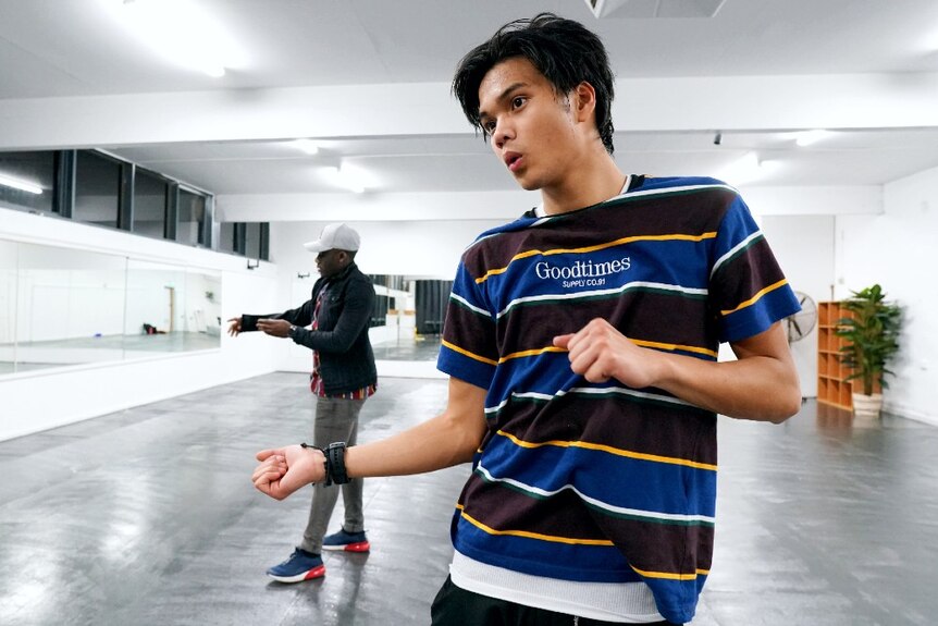 Two young men dance together in a dance studio