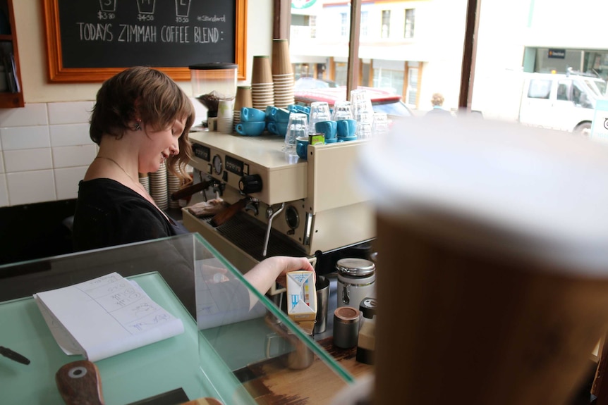 Barista at coffee machine