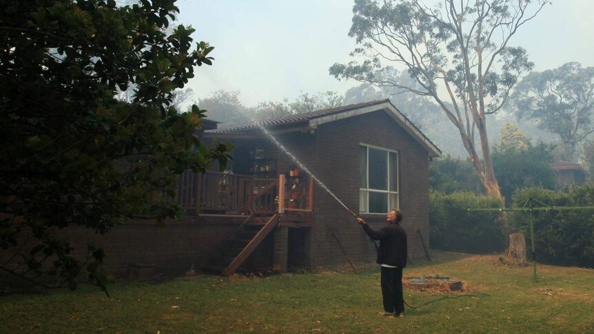 A resident hoses his house in Faulconbridge.