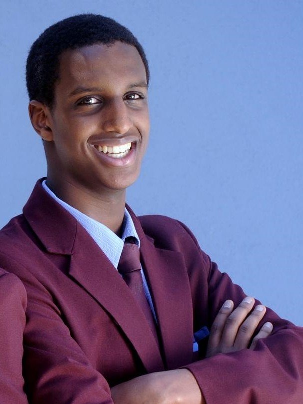 Raghe Mohammed Abdi smiles in his school uniform.