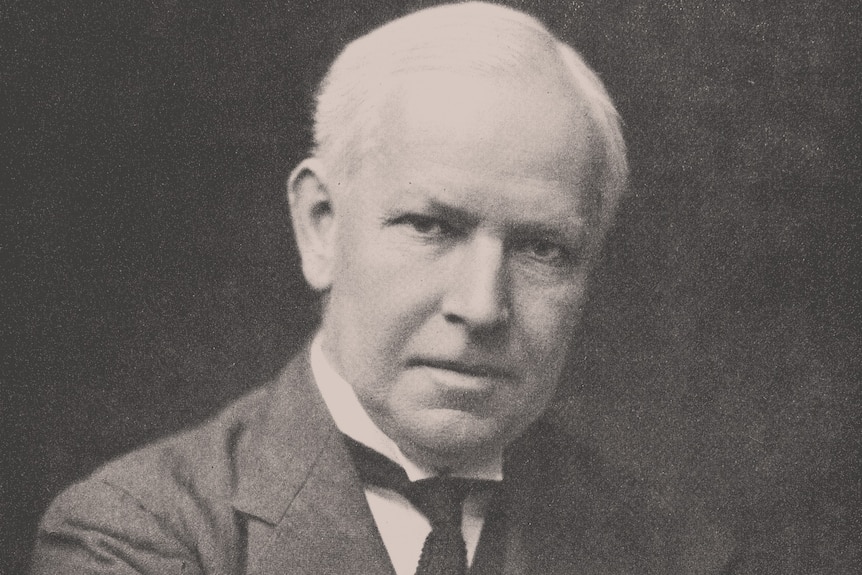 An early 1900s black and white photo of an older man in a suit