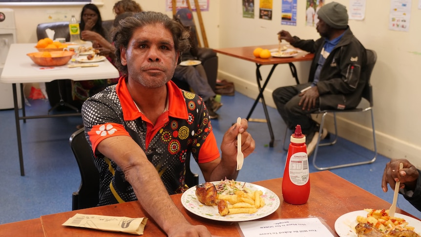 A man sits eating a meal.