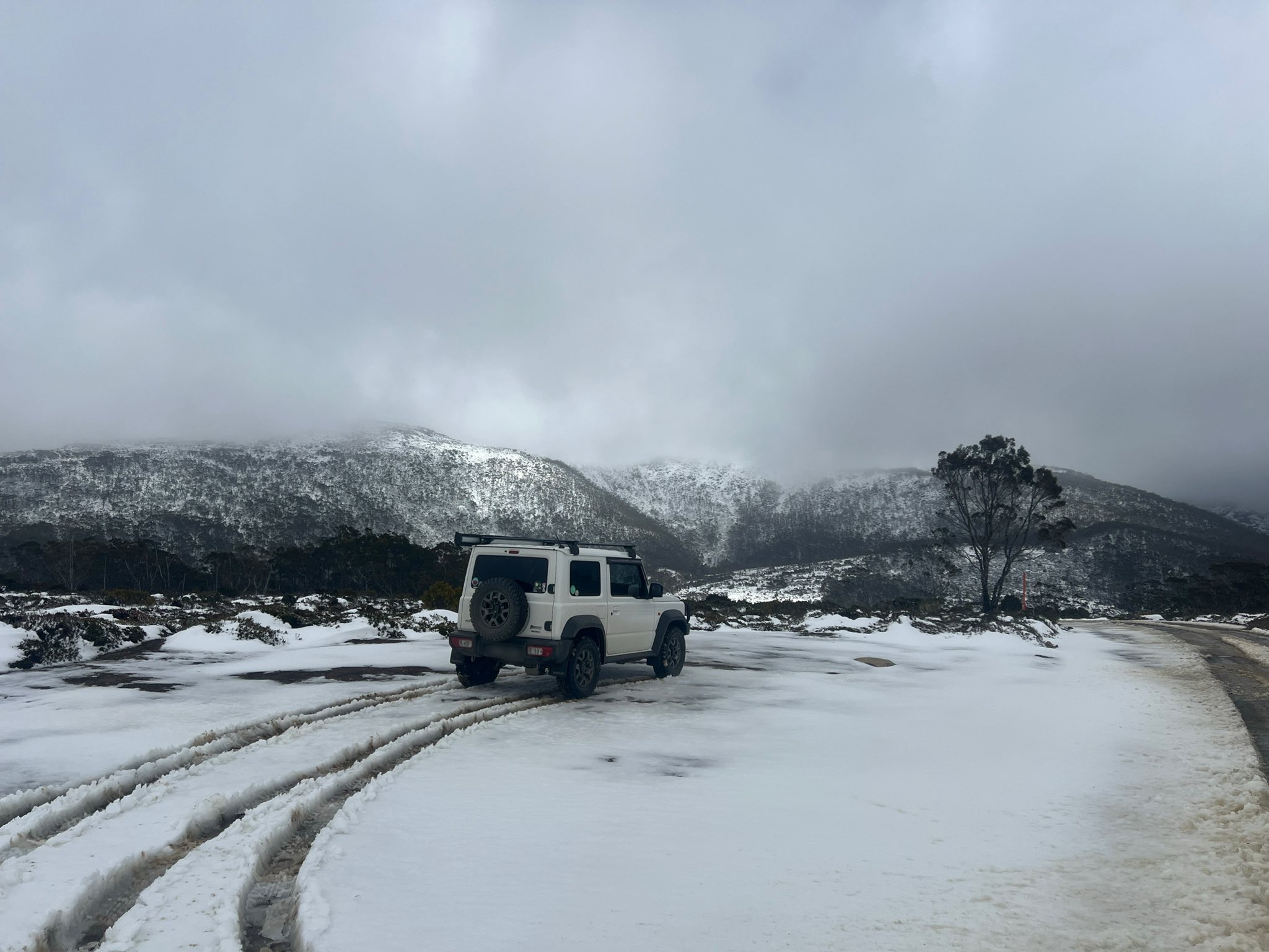 Uma estrada coberta de neve na Tasmânia enquanto um caminhão passa por ela