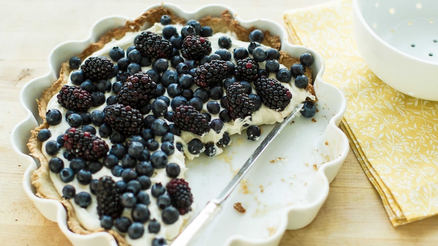 A sweet tart topped with blueberries and blackberries.