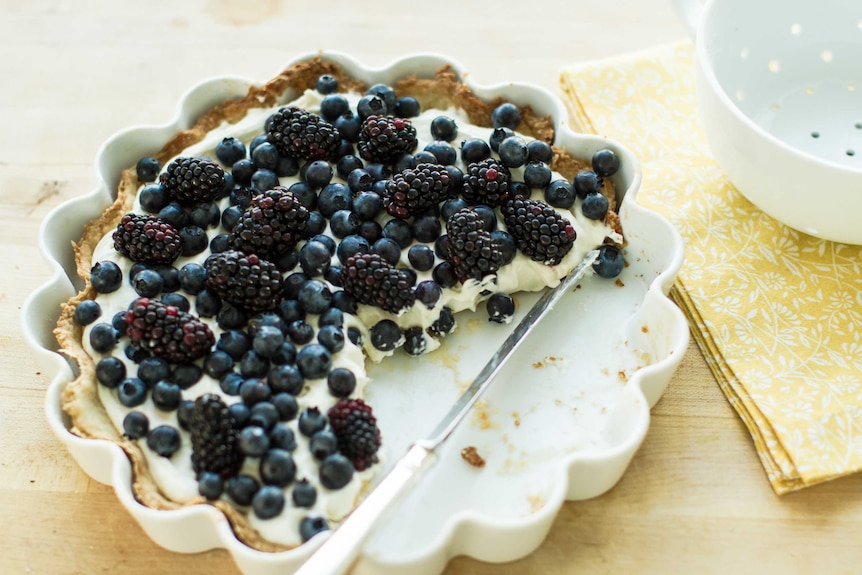 A sweet tart topped with blueberries and blackberries.