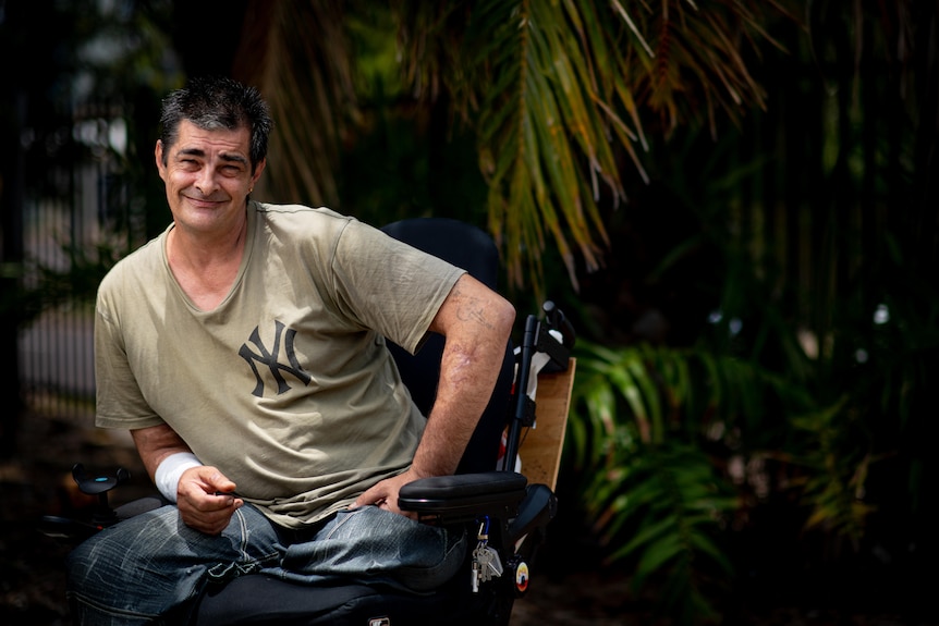 Paul Johnes looks at the camera in front of a tropical garden.