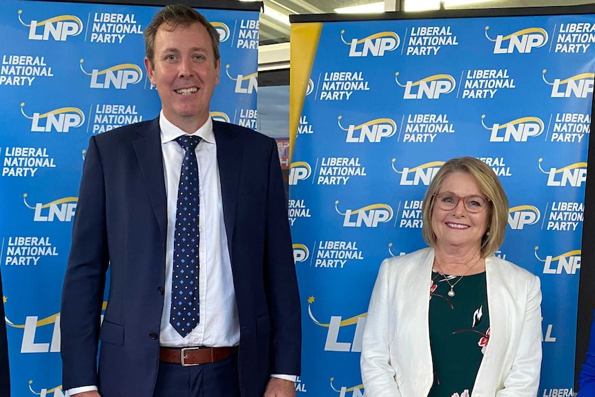 A man and woman in front of LNP banner.