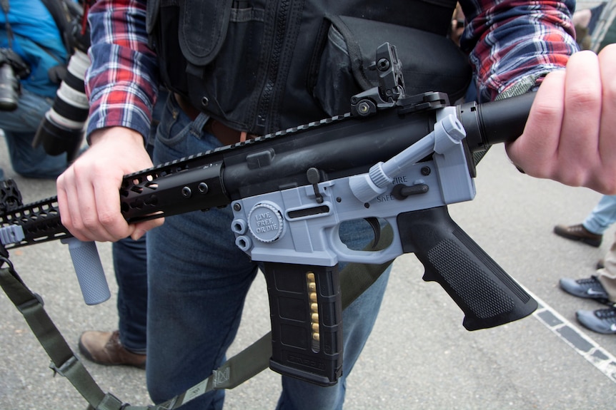 A participant at a rally shows a 'ghost gun'