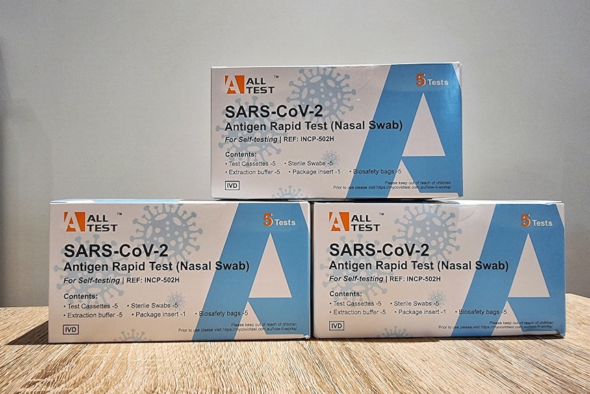 three white boxes of rapid antigen tests with a large blue letter A on each. 