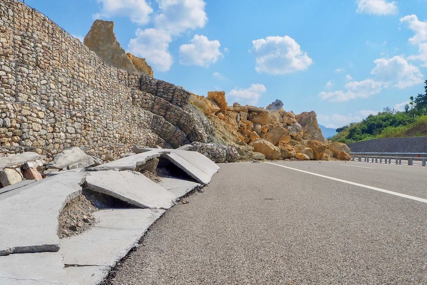 A huge pile of rocks strewn across a freeway