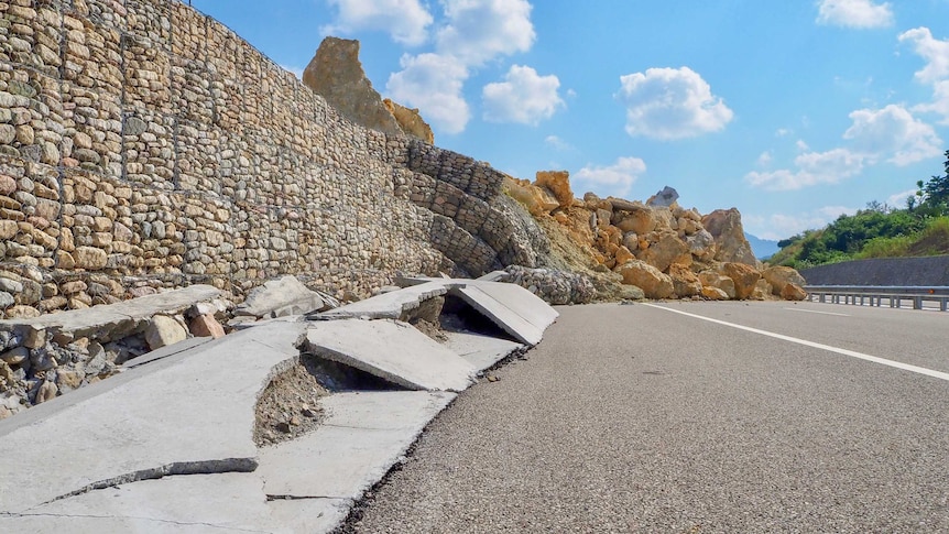 A huge pile of rocks strewn across a freeway
