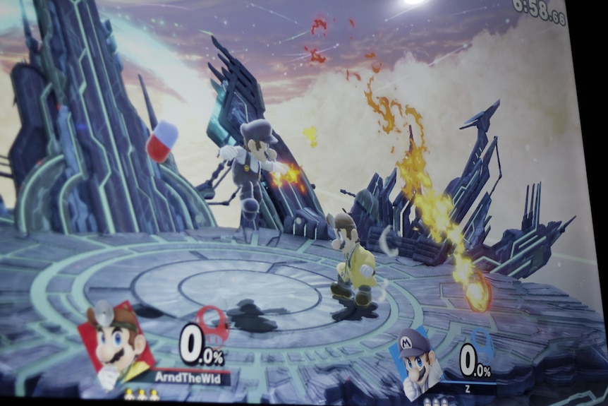 A Super Smash Bros game on a computer screen shows two avatars fighting.