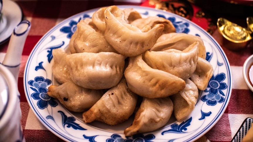 Lunar New Year dumplings in a bowl on a festive table setting.