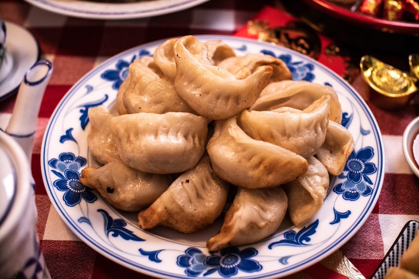 Lunar New Year dumplings in a bowl on a festive table setting.