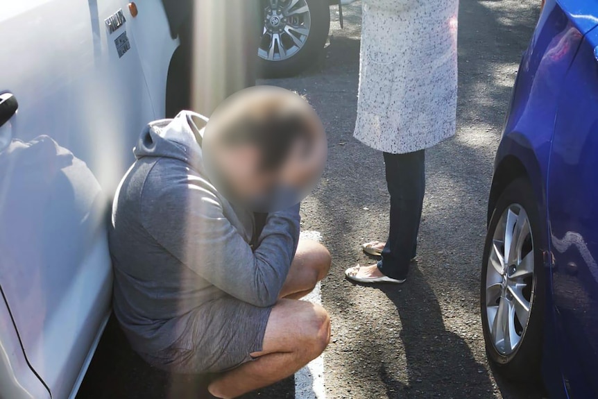 A blurred man is arrested by police and led in handcuffs