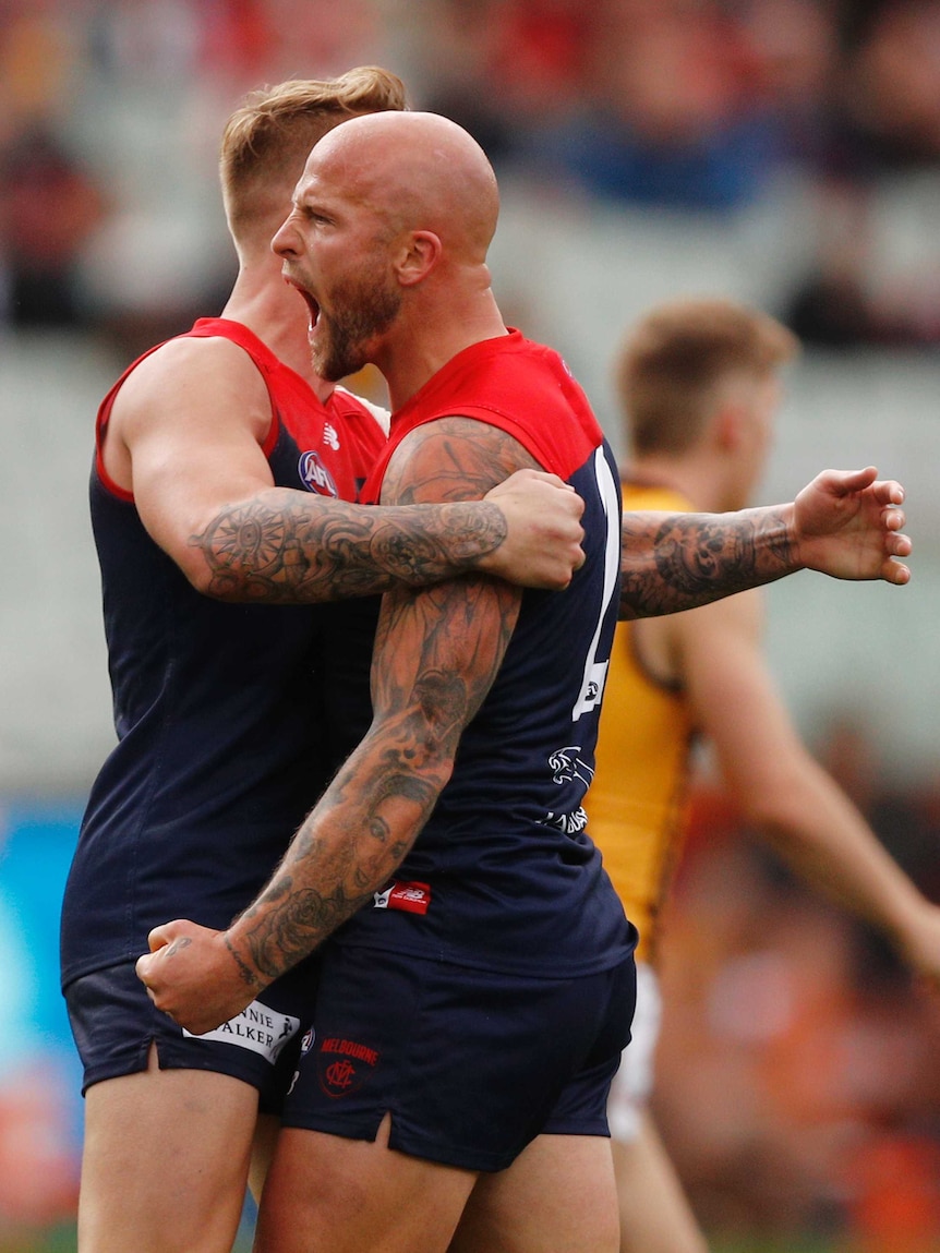 Nathan Jones and James Harmes hug after kicking a Demons goal.