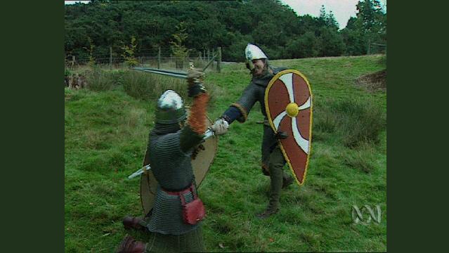 Two men in period costume wield swords at each other