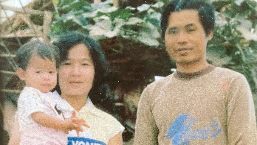 Chi Chu held by her mother Doan Chu. Minh Chu stands beside her father Van Du Chu.