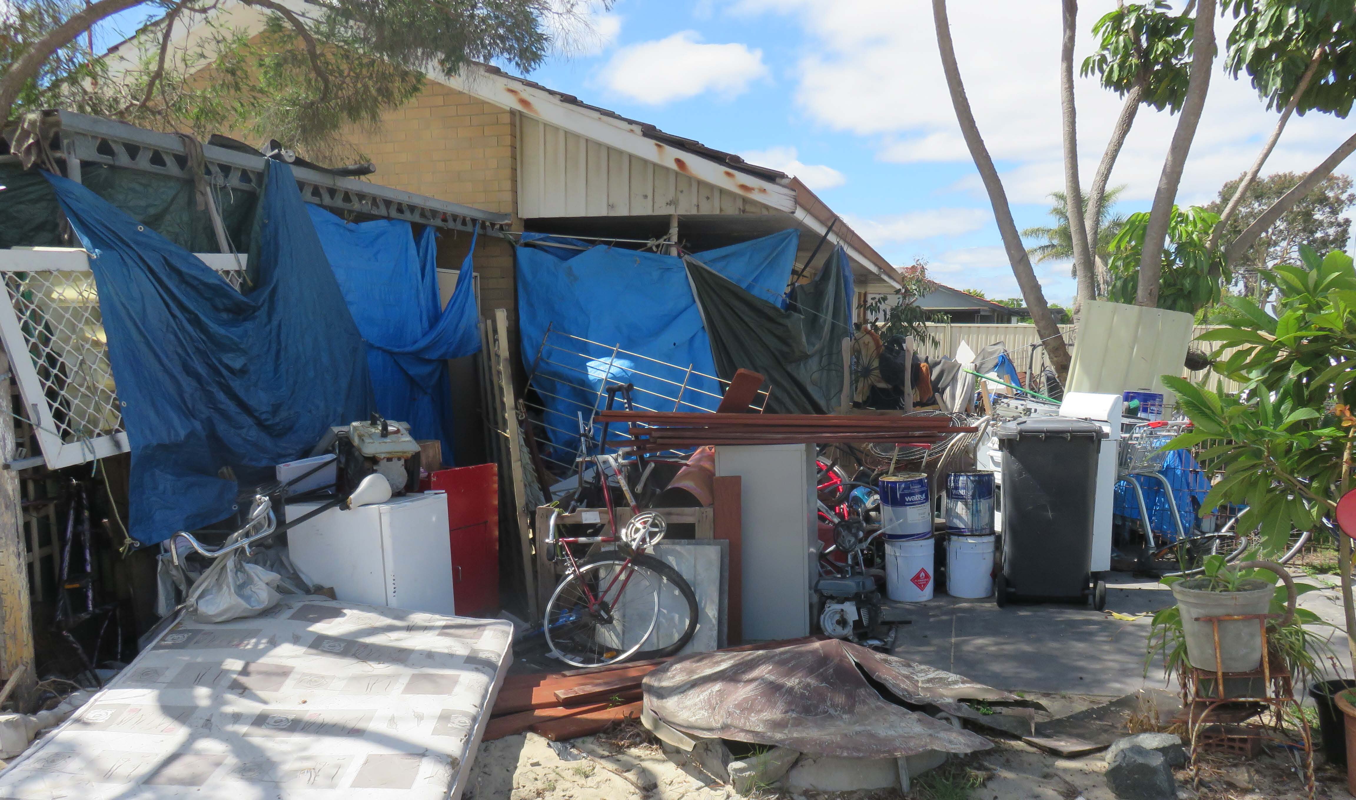 A picture of a house surrounded by clutter and debris