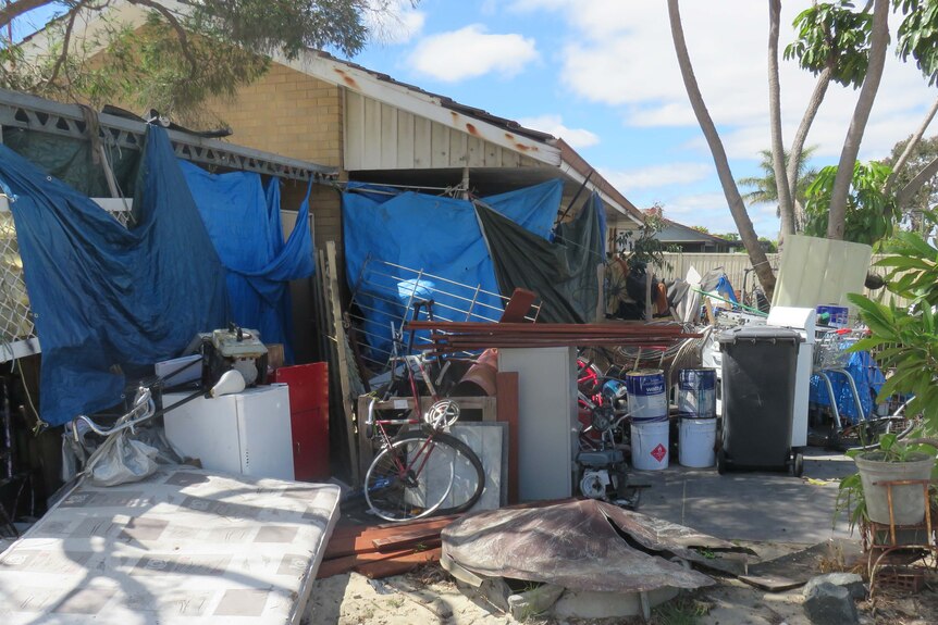 A picture of a house surrounded by clutter and debris